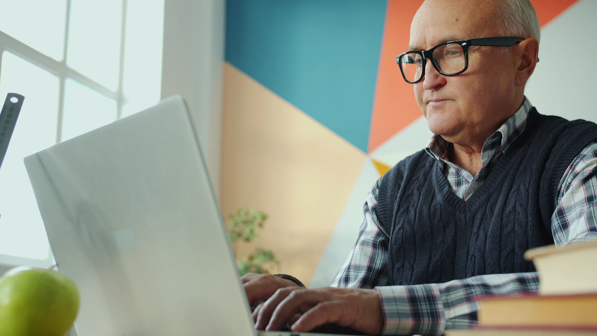 Hombre mayor con gafas trabajando con el portátil