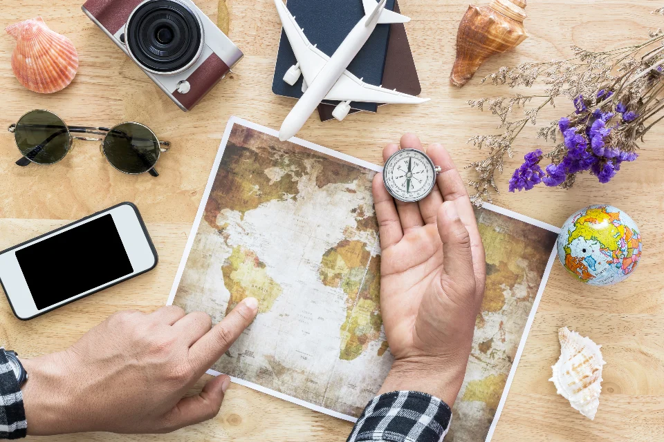 Mapa del mundo con una brújula y objetos de viaje